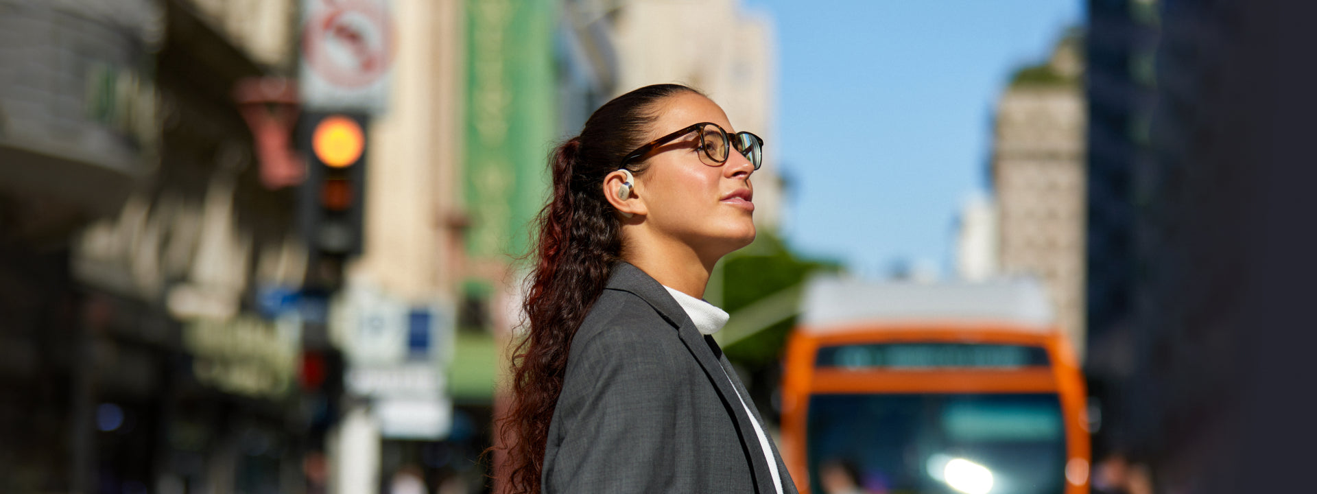 person navigating through city streets with Shokz OpenFit headphones